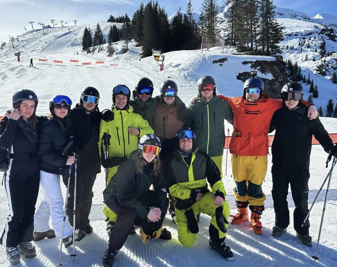 Un groupe de collègues en tenue de ski sur la piste