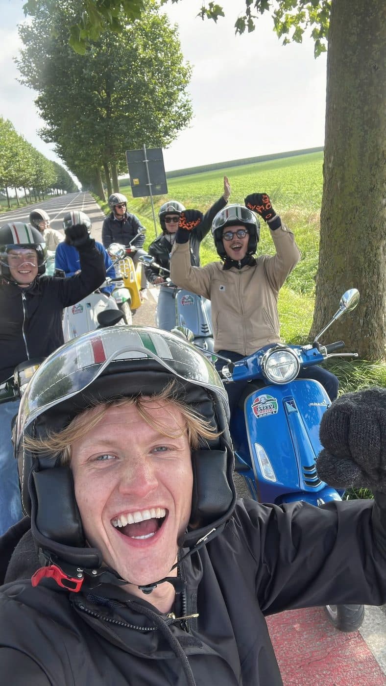 Un groupe de collègues en Vespa, en route à travers les champs