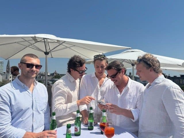 Collega's in het wit op het dakterras, onder de parasols