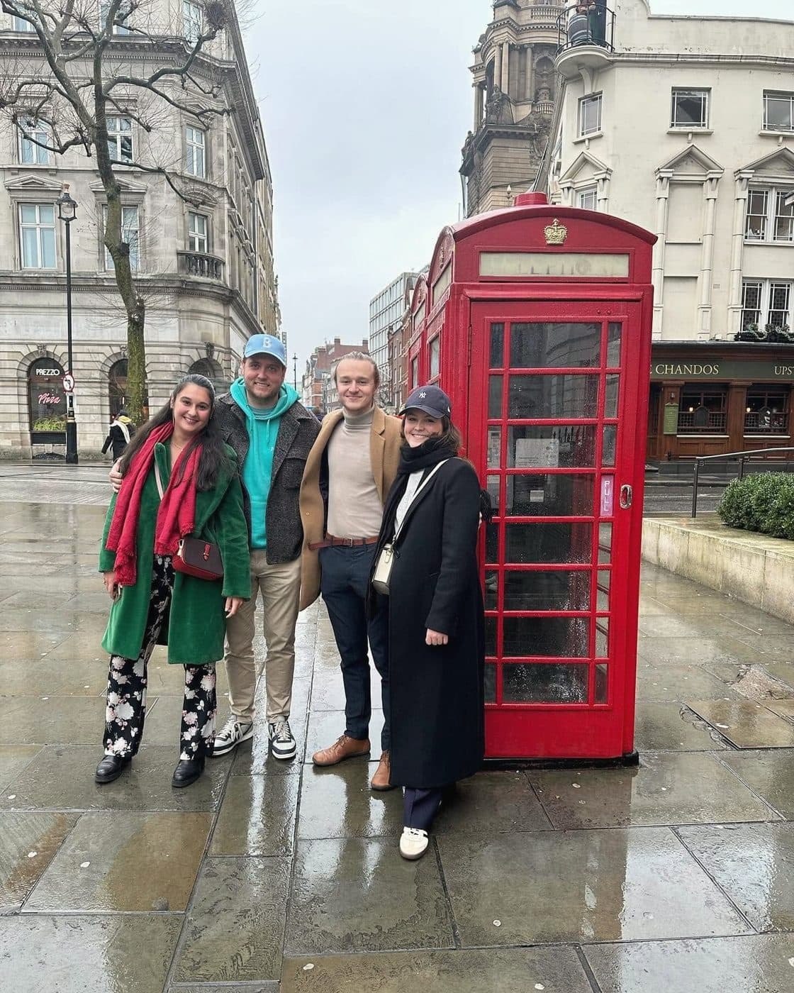 Vier collega's bij een rode telefooncel in Londen